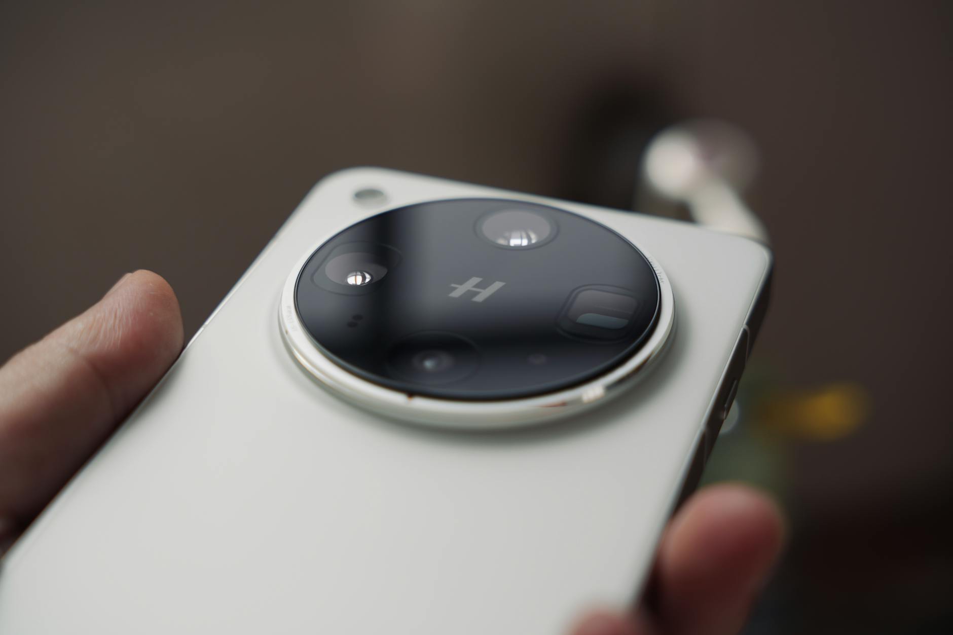 Detailed macro shot of a modern smartphone's triple lens camera held in hand.