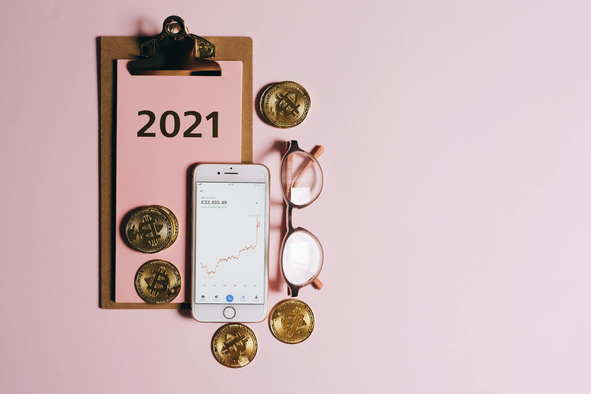 Modern flat lay showing bitcoin coins, smartphone, and clipboard for digital currency finance concept.