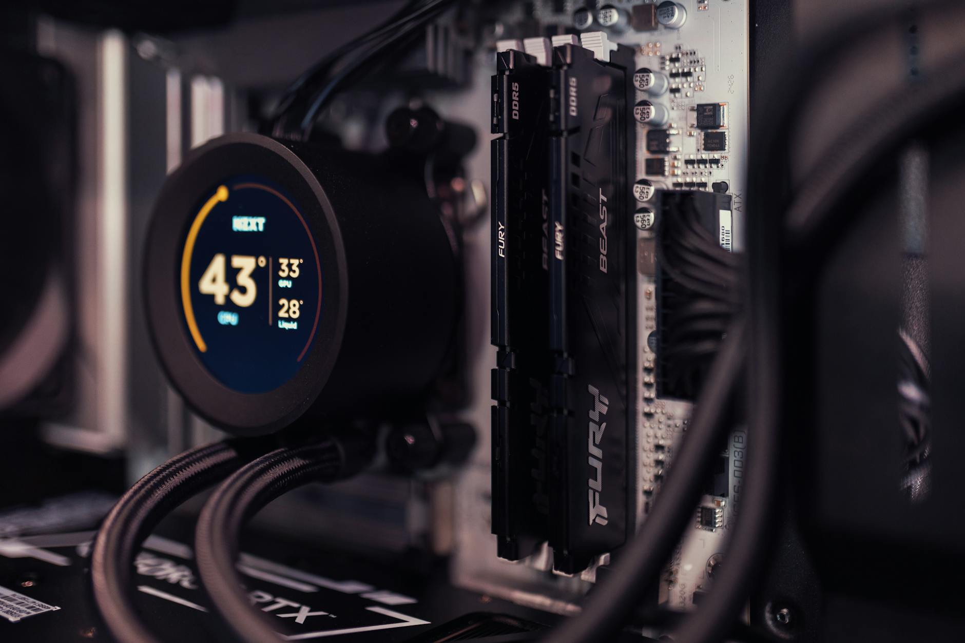 Detailed view of a gaming PC's interior featuring RAM and a digital CPU cooler display.