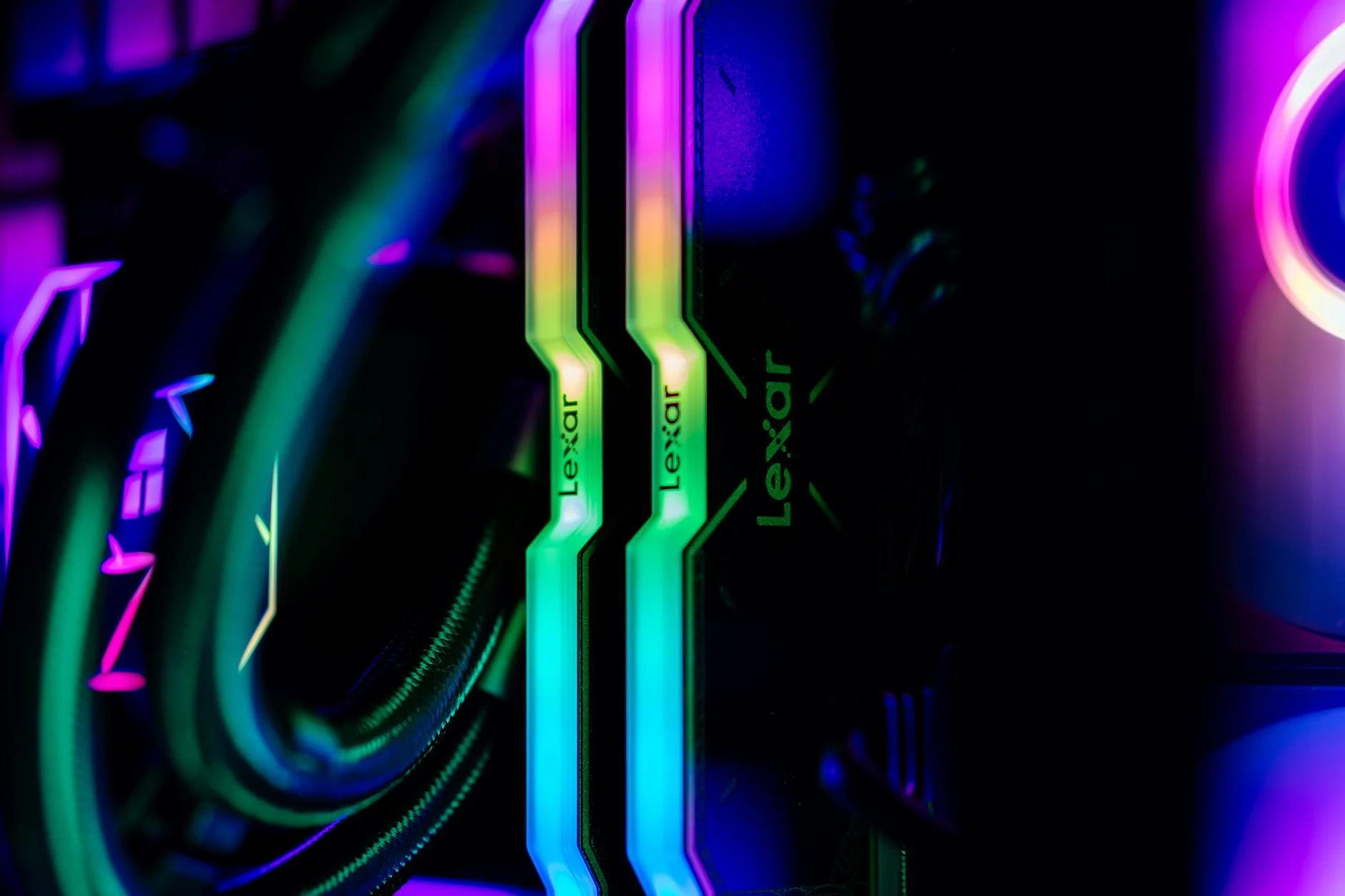 Close-up of RGB lighting on Lexar memory sticks inside a custom gaming PC case, showcasing modern technology.
