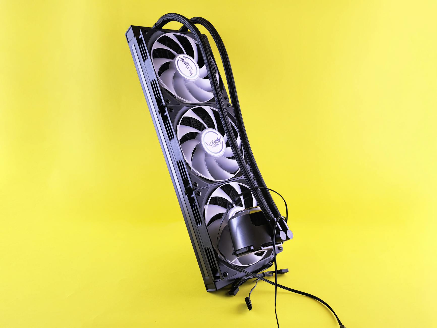 A sleek triple fan liquid cooler on a vibrant yellow background, showcasing modern cooling technology.